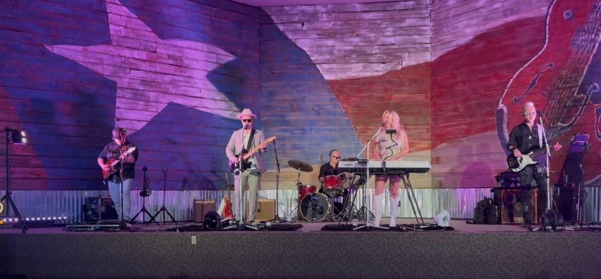 Texanadian performing on stage with a full band.