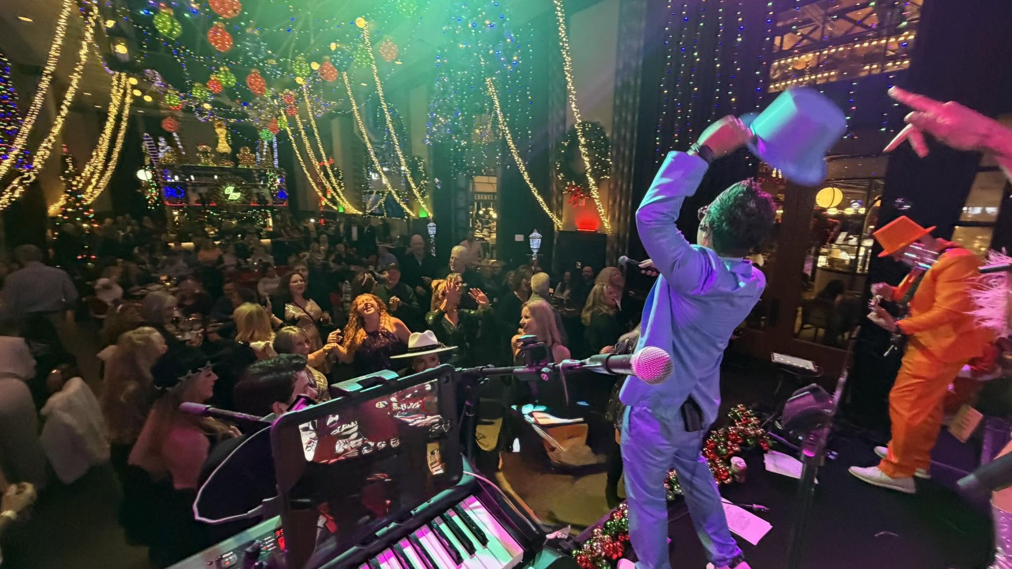 Fun & Funner performing to a crowded dance floor during a celebration.
