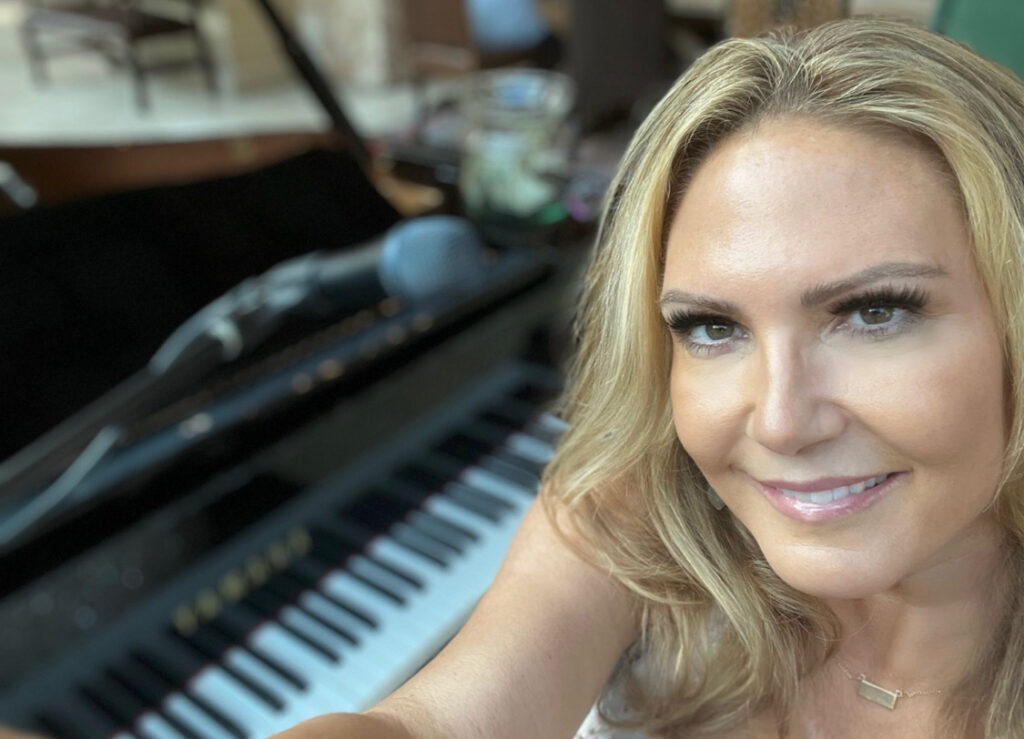 Dālene Richelle smiling beside a piano keyboard.