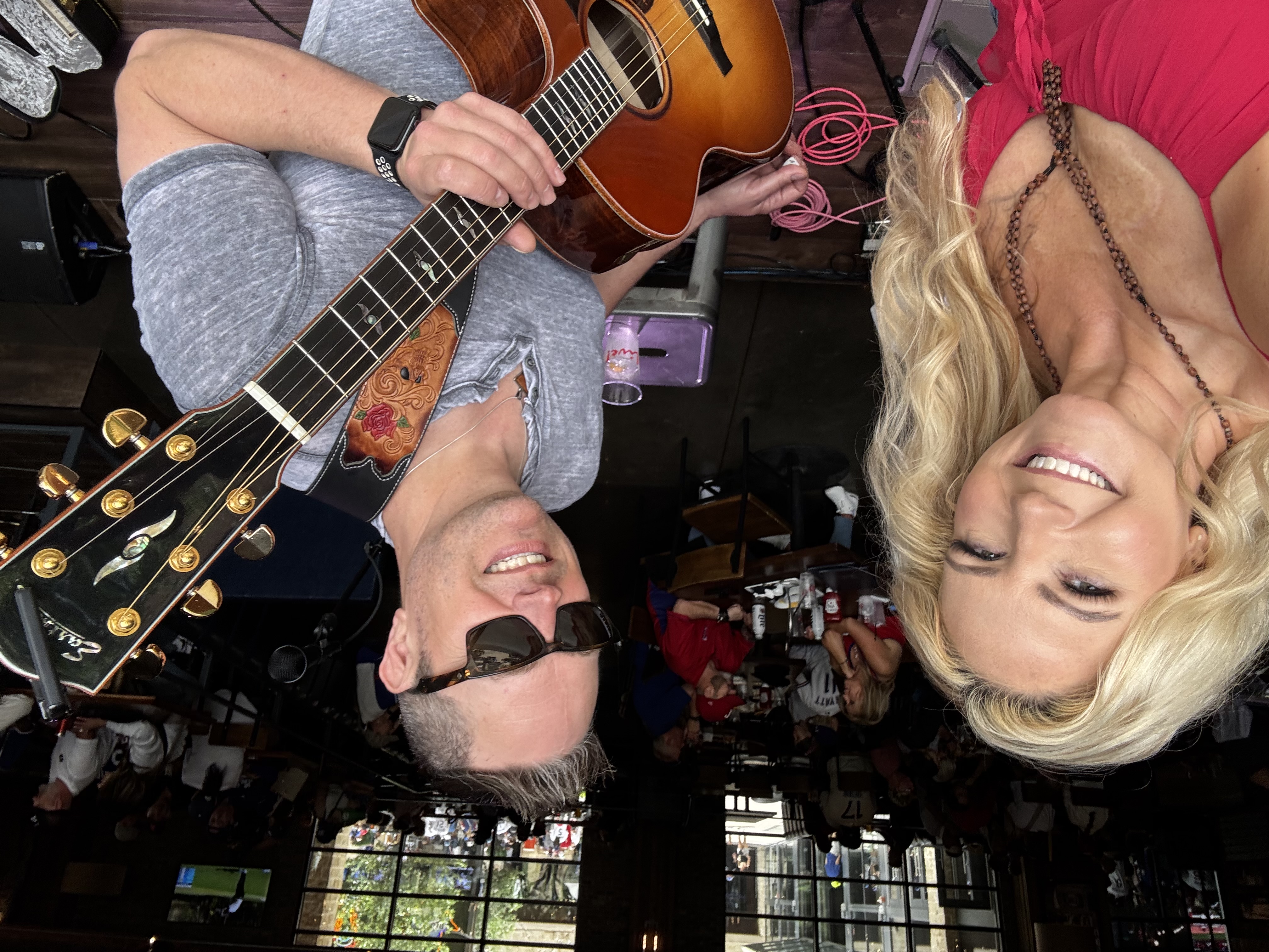 Dālene Richelle and Scott E together at a duo performance, with Scott holding an acoustic guitar.